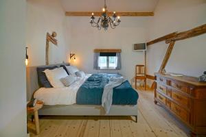 EysVakantiehuis Dur Piepert的一间卧室配有一张床、梳妆台和吊灯。