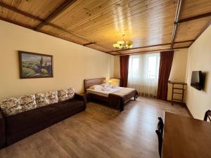 卡缅涅茨-波多利斯基塔拉斯布巴酒店的客厅配有床和沙发