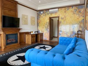 卡缅涅茨-波多利斯基塔拉斯布巴酒店的客厅设有蓝色的沙发和壁炉