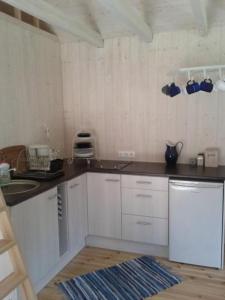 KassariTirbi Holiday House的厨房配有白色橱柜和台面