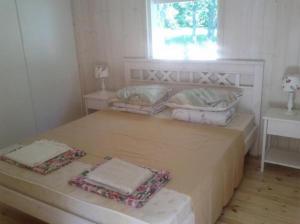 KassariTirbi Holiday House的一间卧室配有带两个枕头的床和窗户