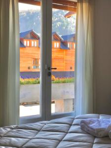 圣马丁德洛斯Hotel Crismalu的一间卧室设有一张床和一个大窗户