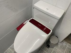 济州市Cozy Sinchon 2548的浴室内的白色卫生间,配有遥控器
