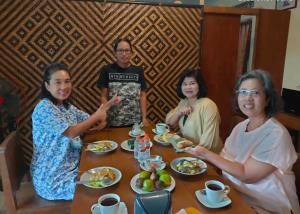 婆罗浮屠艾法塔民宿的一群坐在餐桌旁吃食物的妇女