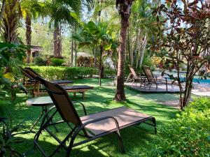 格兰德海滩Hotel El Manglar的一个带桌椅的庭院和一个游泳池