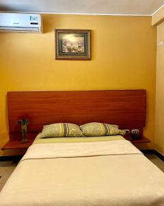 瓜亚基尔Hostal Montesa的一张带木制床头板的床
