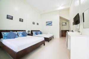 长滩岛Shorebreak Boracay Resort的一间酒店客房,设有两张床和电视