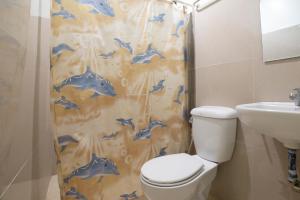 长滩岛Shorebreak Boracay Resort的浴室设有淋浴帘、卫生间和水槽