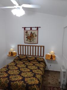 拉博尔萨El Tatu的卧室配有一张床,墙上有两盏灯