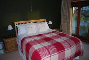英格尔顿摩尔景致住宿加早餐旅馆的窗户客房内的一张红白色的床