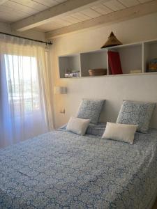 圣特奥多罗Porto Coda Cavallo的一间卧室配有带两个枕头的床和窗户