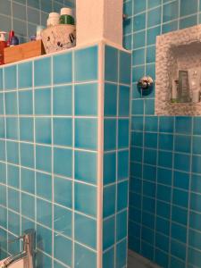 圣特奥多罗Porto Coda Cavallo的浴室设有蓝色瓷砖墙壁和水槽