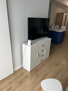 卡托维兹Marcinkowskiego 11 - 2的客厅配有白色橱柜和电视