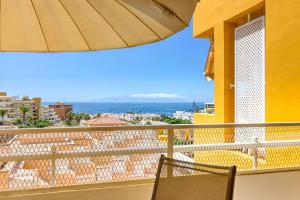 阿德耶Orlando - Ocean View Apartment in Costa Adeje的阳台配有椅子和遮阳伞。