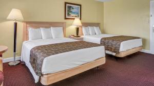 圣徒皮特海滩Page Terrace Beachfront Hotel的酒店客房设有两张床和两盏灯。