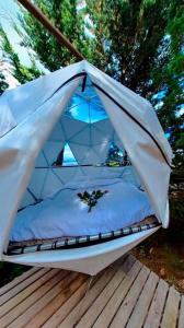 瓜斯卡Glamping El Edén Guasca Cundinamarca的甲板上帐篷内的一张床位