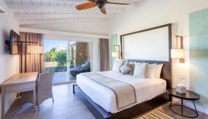 East EndWyndham Tortola BVI Lambert Beach Resort的一间卧室配有一张床、一张桌子和一张书桌