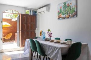 库鲁Villa Comfort-Soleil的用餐室配有带绿椅的桌子
