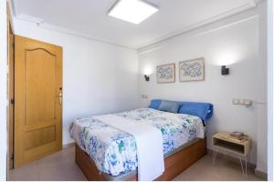 贝尼多姆Payma Apartments Benidorm的小卧室配有一张带蓝色床罩的床
