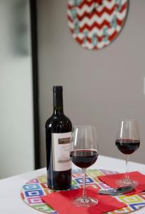 墨西哥城Kolben Nuoma的桌子上放有一瓶葡萄酒和两杯酒