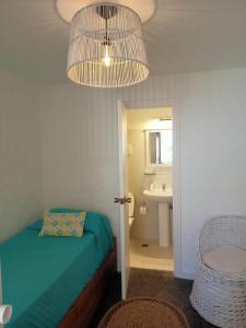 埃斯特角城El Remanso - Suite 104的一间卧室配有一张床、一个水槽和一个吊灯。