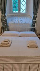 芬奇Casina di Alice的一张带两条毛巾的床和窗户