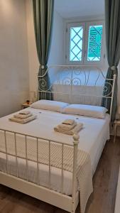 芬奇Casina di Alice的一间卧室配有一张带白色床单的床和一扇窗户。