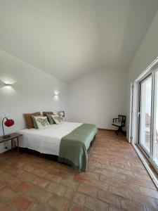 阿尔莫多瓦Corvatos Casas do Monte的一间卧室设有一张床和一个大窗户