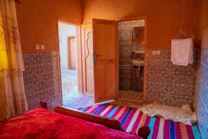 Aït BoukhaMaison etoile du desert的一间卧室配有一张床,浴室设有淋浴。