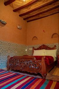 Aït BoukhaMaison etoile du desert的一间卧室,卧室内配有一张木床