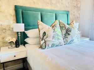 约翰内斯堡Nal'enzo Luxe Stays的一张带绿色床头板和枕头的床