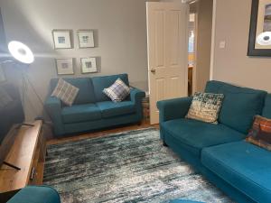 阿维莫尔Linmore的客厅配有2张蓝色的沙发和1张桌子