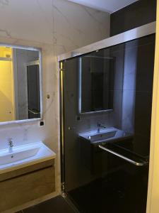 普里什蒂纳TOP APARTMENTS的一间带两个水槽和玻璃淋浴间的浴室