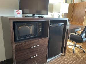 克奇坎Super 8 by Wyndham Ketchikan的电视,位于一个带微波炉的木柜上