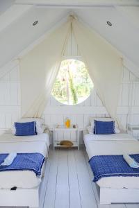 卢纳将军城灵魂部落海滩度假村的带帐篷的客房内的两张床
