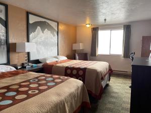 克奇坎Super 8 by Wyndham Ketchikan的酒店客房设有两张床和窗户。