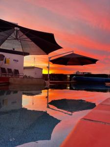 巴加拉巴加拉布鲁度假酒店的日落时分在水中带两把遮阳伞的游泳池