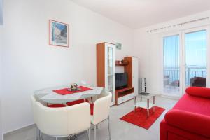 奥库格哥恩基Apartments by the sea Okrug Donji, Ciovo - 19974的客厅配有桌子和红色沙发