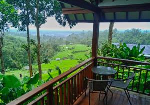 贝都古云上村庄旅馆的设有一个配有桌椅并享有美景的阳台。