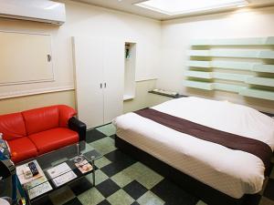 Yoshiokaメルヘンの森パート2大人専用的一间卧室配有一张床和一张红色的沙发