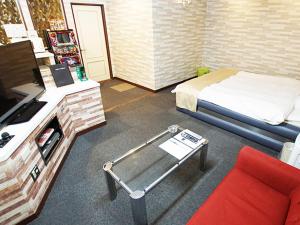Yoshiokaグリーンヒル　大人専用的客房设有床、书桌和沙发。