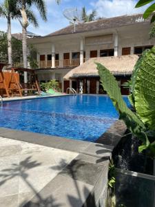 圣吉吉Central Inn Senggigi的一座带度假村的别墅前的游泳池