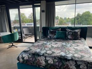 赞丹Above and Beyond - luxe suite met sauna en stoomdouche的一间卧室设有一张床,享有阳台的景色