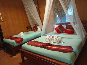 考索Khao Sok River & Jungle Resort的客房内的两张床和毛巾