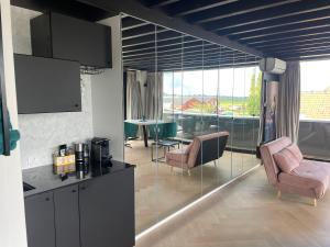赞丹Above and Beyond - luxe suite met sauna en stoomdouche的厨房以及带桌椅的起居室。