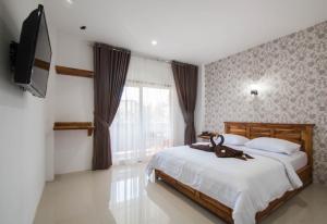圣吉吉Central Inn Senggigi的一间卧室配有一张床和一台平面电视