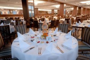 阿菲永ALUSSO THERMAL HOTEL SPA的一间设有白色桌椅的用餐室