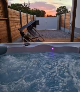 CoulogneA Fleur de Spa : Maison chaleureuse avec spa privatif et billard.的后院的热水浴池和野餐桌