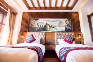 加德满都Everest Boutique Hotel的酒店客房设有两张床,墙上挂有绘画作品