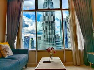 吉隆坡De Sky Suites KLCC Kuala Lumpur的客厅设有蓝色的沙发和大窗户